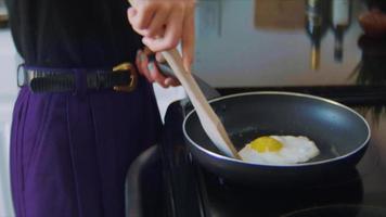 Young woman making eggs in a skillet video