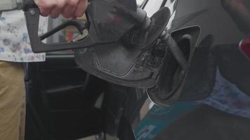 Mann in der Tankstelle nimmt eine Düse aus seinem Auto video