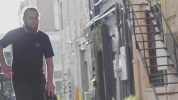 homme dans la ruelle tenant sa planche à roulettes et la laissant tomber video