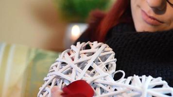 Valentine Gift. Young Girl holding white wooden heart with rose petals video