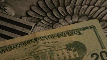rotação de imagens de estoque de papel-moeda americano em um fundo de escudo de águia americana - dinheiro 0405 video