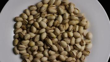 Cinematic, rotating shot of pistachios on a white surface - PISTACHIOS 025 video