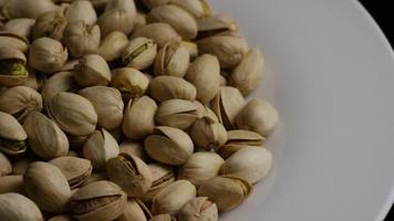 Cinematic, rotating shot of pistachios on a white surface - PISTACHIOS 035 video