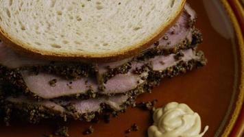 Tir rotatif d'un délicieux sandwich au pastrami de première qualité à côté d'une cuillerée de moutarde de Dijon - nourriture 039
