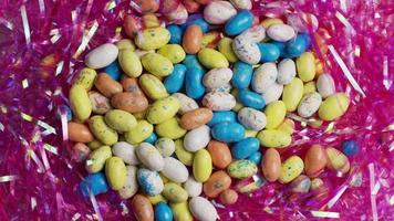 Foto giratoria de coloridos dulces de Pascua sobre un lecho de pasto de Pascua - Pascua 110 video