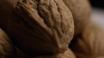 Cinematic, rotating shot of walnuts in their shells on a white surface - WALNUTS 093 video