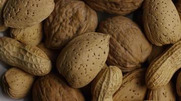 Cinematic, rotating shot of a variety of nuts on a white surface - NUTS MIXED 006 video