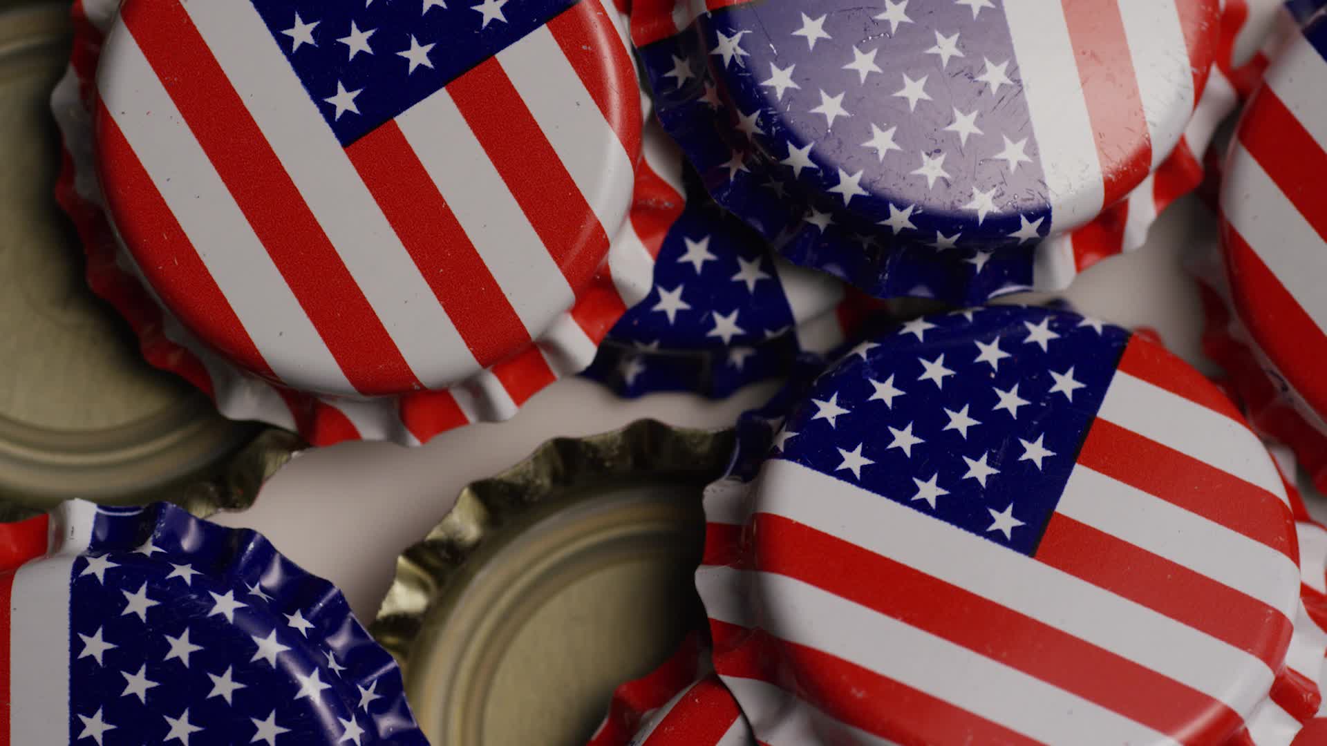 Rotating shot of bottle caps with the American flag printed on them