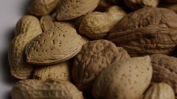 Cinematic, rotating shot of a variety of nuts on a white surface - NUTS MIXED 018 video