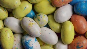 Foto giratoria de coloridos dulces de Pascua sobre un lecho de pasto de Pascua