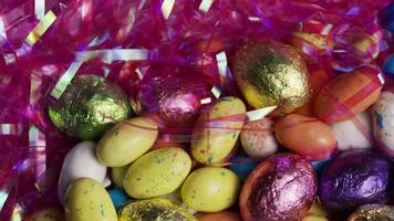 Foto giratoria de coloridos dulces de Pascua sobre un lecho de pasto de Pascua - Pascua 160 video