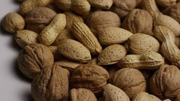 Cinematic, rotating shot of a variety of nuts on a white surface - NUTS MIXED 015 video