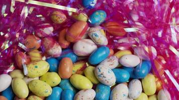 Rotating shot of colorful Easter candies on a bed of easter grass - EASTER 112