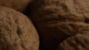 filmische, roterende opname van walnoten in hun schelp op een wit oppervlak - walnoten 019 video