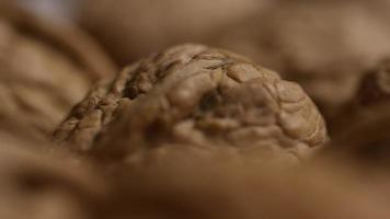 Cinematic, rotating shot of walnuts in their shells on a white surface - WALNUTS 039 video