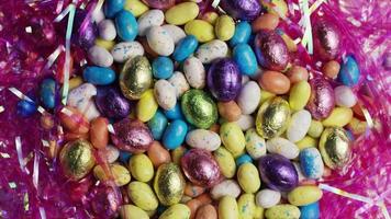 Foto giratoria de coloridos dulces de pascua sobre un lecho de pasto de pascua - pascua 157 video