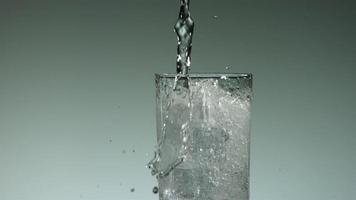 Liquide carbonaté clair versant et éclaboussant en ultra-lent mouvement (1500 images par seconde) dans un verre rempli de glace - liquide verser 016 video