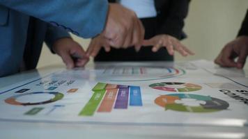 Group business people coming during explain discussions on financial charts and business graphs video