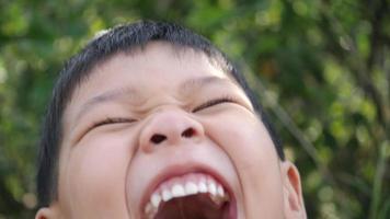 Nahaufnahme kleiner Junge lacht und lächelt, nachdem er eine Witzgeschichte gehört hat video