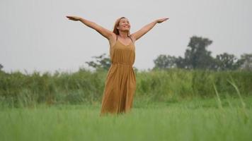 Beautiful Young Woman standing with arms raised enjoy in nature