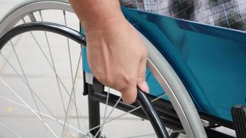 Close-up of a patient's hand holding a wheelchair and driving it alone video