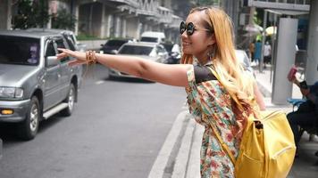 Voyageur femme salue une voiture de taxi dans la ville video