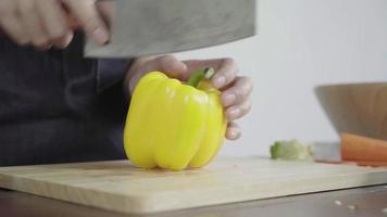 Close up of chief woman making salad healthy food and chopping bell pepper on cutting board. video