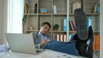 Tired and lazy young man sitting at office video