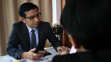 Businessmen coming together at office desk and checking a financial report. video