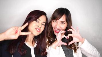 Two happy and attractive business women after completing a project video