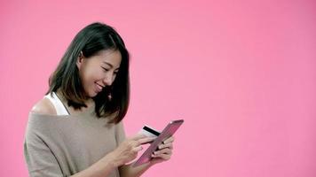 jonge Aziatische vrouw met behulp van tablet kopen online winkelen met een creditcard gevoel gelukkig lachend. video