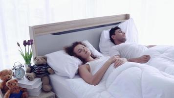 Couple wake up and hug on the bed.