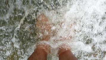 Cerca de relajantes pies en una cascada. video