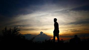 silhouettes de détente homme avec le fond du ciel coucher de soleil. video
