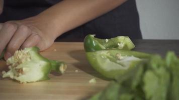 mujer cortando pimiento en la tabla de cortar en la cocina. video