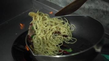 câmera lenta - chefs estão preparando e cozinhando espaguete na cozinha de um restaurante. video