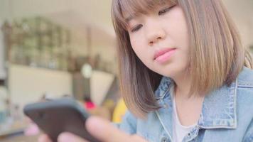 mujer asiática con smartphone en café. video