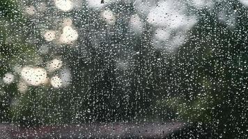 Close up of a window with raindrops falling down video