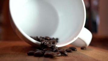 granos de café cayendo en una taza de café en cámara lenta video