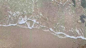 vue de dessus des vagues se brisant sur le sable video