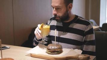 um homem barbudo comendo um hambúrguer video