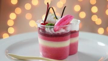 Colorful strawberry cake and macaron in white plate over shiny bokeh background video