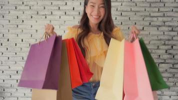 junge asiatische Frau, die Einkaufstasche hält video