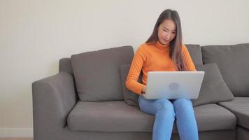 Joven mujer asiática trabajando en un portátil. video