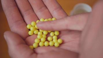 Hand Holding a Pile of Yellow Pills video