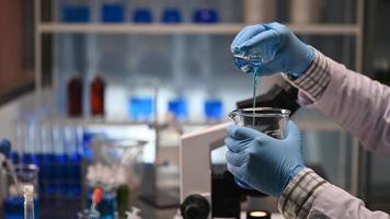 The hands of a scientist mixing chemicals on a lab video