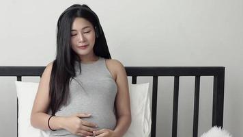 schwangere Frau sitzt auf dem Bett video