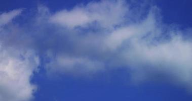 Time lapse of cumulus clouds with transparency moving on blue sky in 4K video