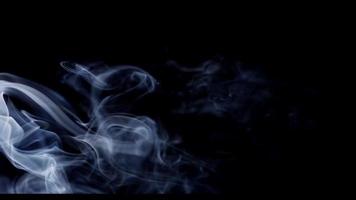 Ethereal texture of white smoke moving from the left and disappearing in darkness in 4K video