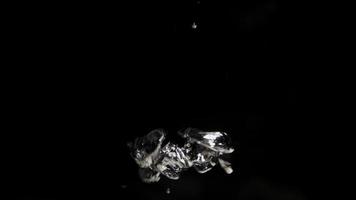 Groups of shiny bubbles moving fast from lower to upper section with black background in 4K video